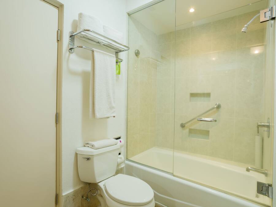 Un baño moderno con ducha envuelta en vidrio, inodoro y bañera.