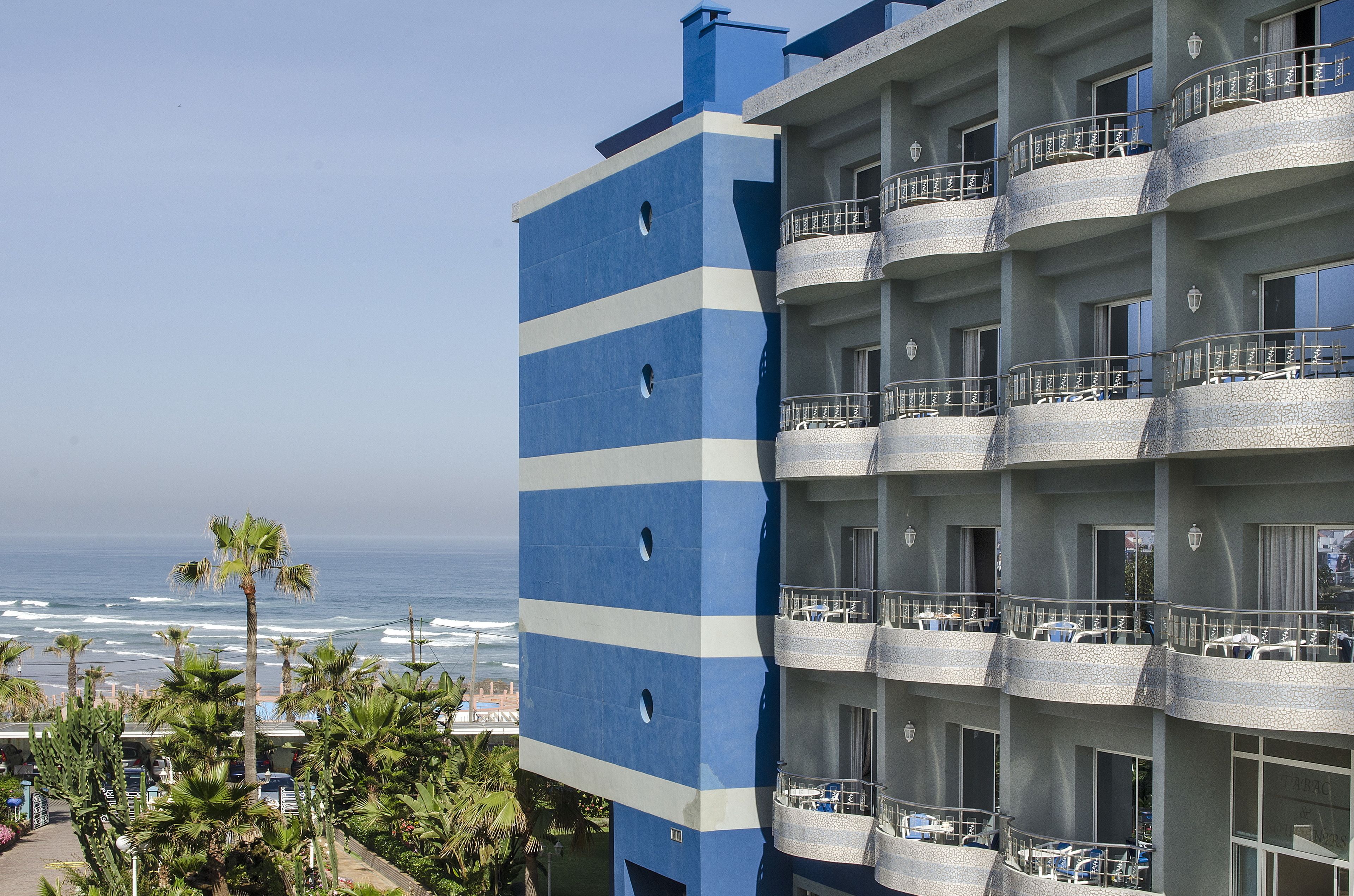 Een hotel met meerdere verdiepingen en balkons met uitzicht op de oceaan.
