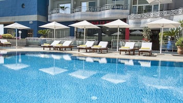 Piscine extérieure, parasols de plage, chaises longues