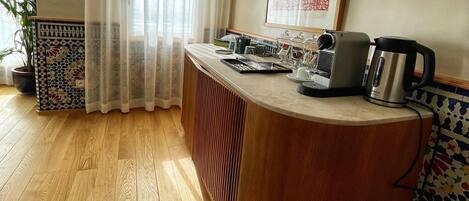 A kitchen with a wooden countertop, a Bosch coffee maker, and a potted plant.