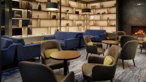 Een moderne zithoek met banken, fauteuils en een open haard.