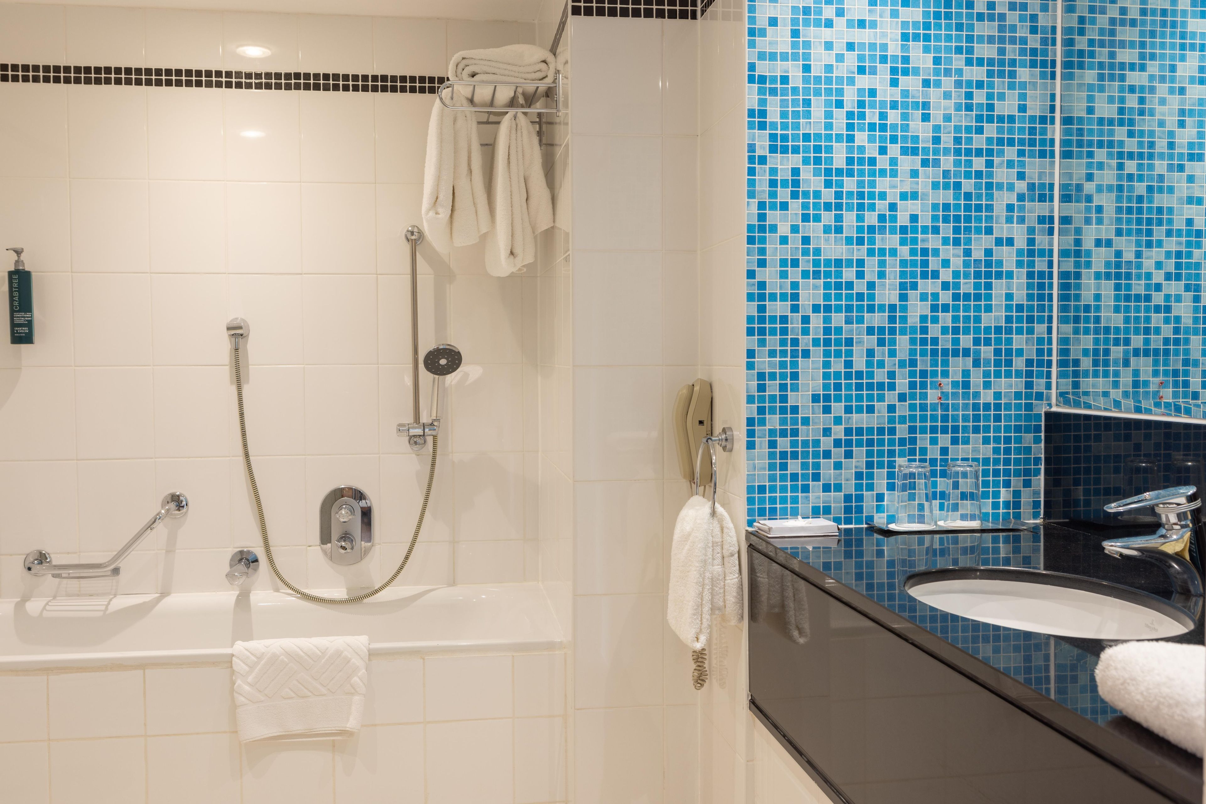 A bathroom with a bathtub, a shower, and a sink.