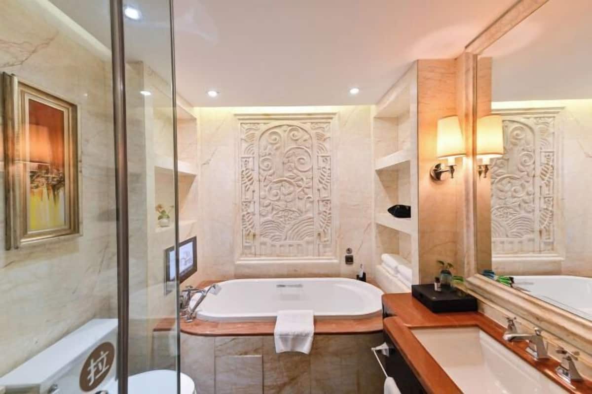 Un baño moderno con una bañera grande, una zona de ducha independiente y un tocador con espejo.