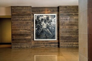 A room with a wooden panel wall and a framed abstract painting.