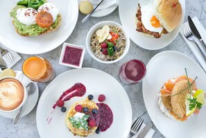 Variedad de platos de desayuno, como panqueques, huevos y salmón ahumado.