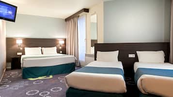 A hotel room with two beds, a television, and a mirror.