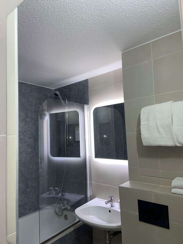 A modern bathroom with a glass-enclosed shower, a white sink, and a towel hanging on the wall. - KYRIAD LILLE GARE - Grand Palais (Lille)