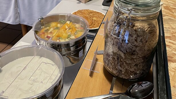 A buffet setup with various food items and utensils. - Hotel La Maison de Lise Mulhouse Illzach (Illzach)