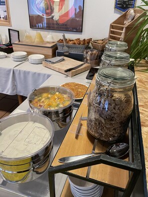 A buffet setup with various food items and utensils. - Hotel La Maison de Lise Mulhouse Illzach (Illzach)