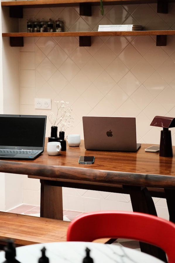 A kitchen with two laptops, a smartphone, and a coffee maker on the counter. - Hôtel Dalila (Paris)