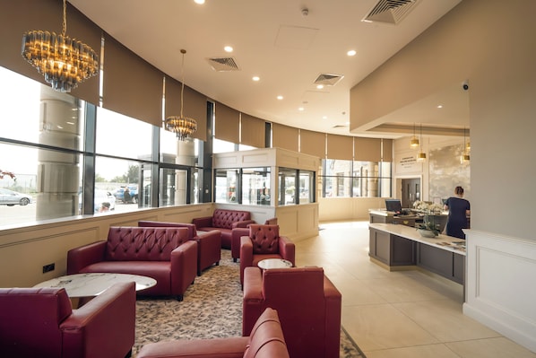 A hotel lobby with seating areas, a reception desk, and large windows. - Da Vinci's Hotel Derry (Londonderry)
