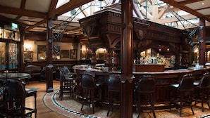 A bar area with wooden furniture and a tiled floor. - Da Vinci's Hotel Derry (Londonderry)