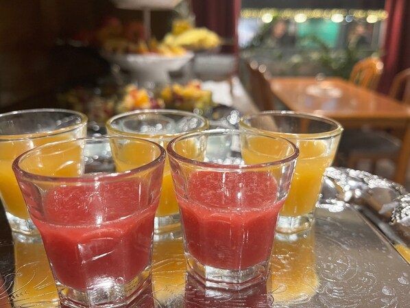 A tray with several glasses of juice and smoothies.