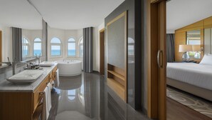 Un bagno d'hotel moderno con una vasca, due lavandini e uno specchio grande.