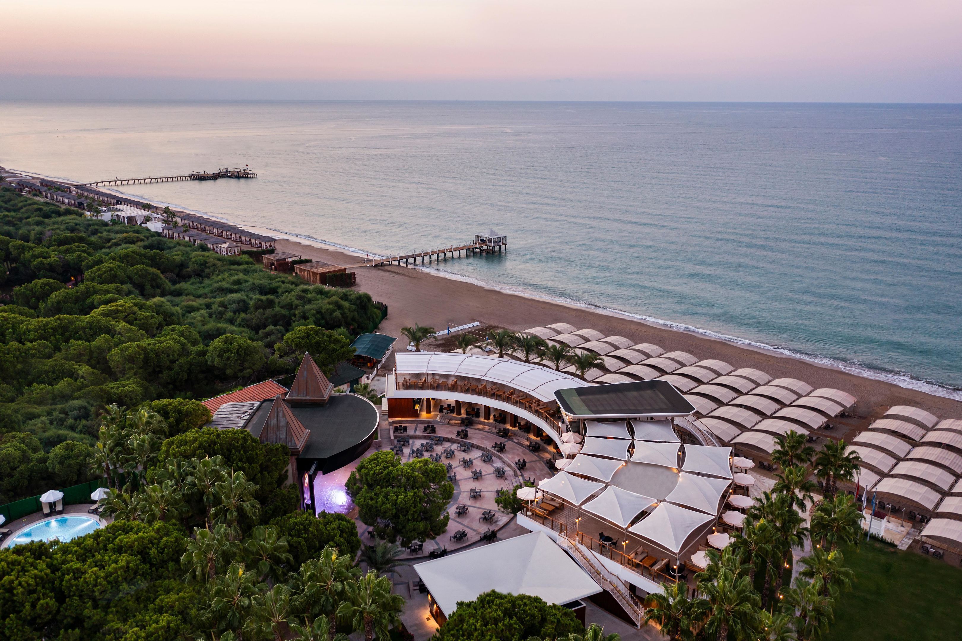 Un complexe hôtelier doté d’une piscine, d’un espace extérieur aménagé et offrant une vue sur la plage.