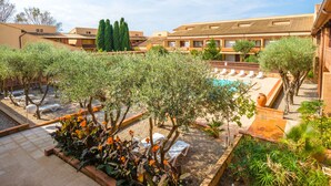 A courtyard with a swimming pool, lounge chairs, and olive trees. - Résidence Lagrange Vacances du Golf (Saint-Cyprien)