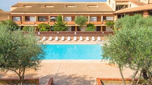 A hotel with a swimming pool surrounded by olive trees, a terrace with lounge chairs, and a multi-story building with balconies. - Résidence Lagrange Vacances du Golf (Saint-Cyprien)