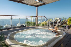 Ein Whirlpool auf einer Terrasse mit Blick auf die Stadt.