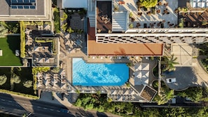 Vue aérienne d’un hôtel doté d’une piscine, d’un espace de détente extérieur et d’un jardin.