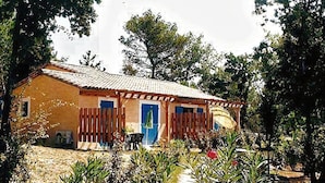 A single-story building with a tiled roof, a wooden fence, and a pathway leading to the entrance.