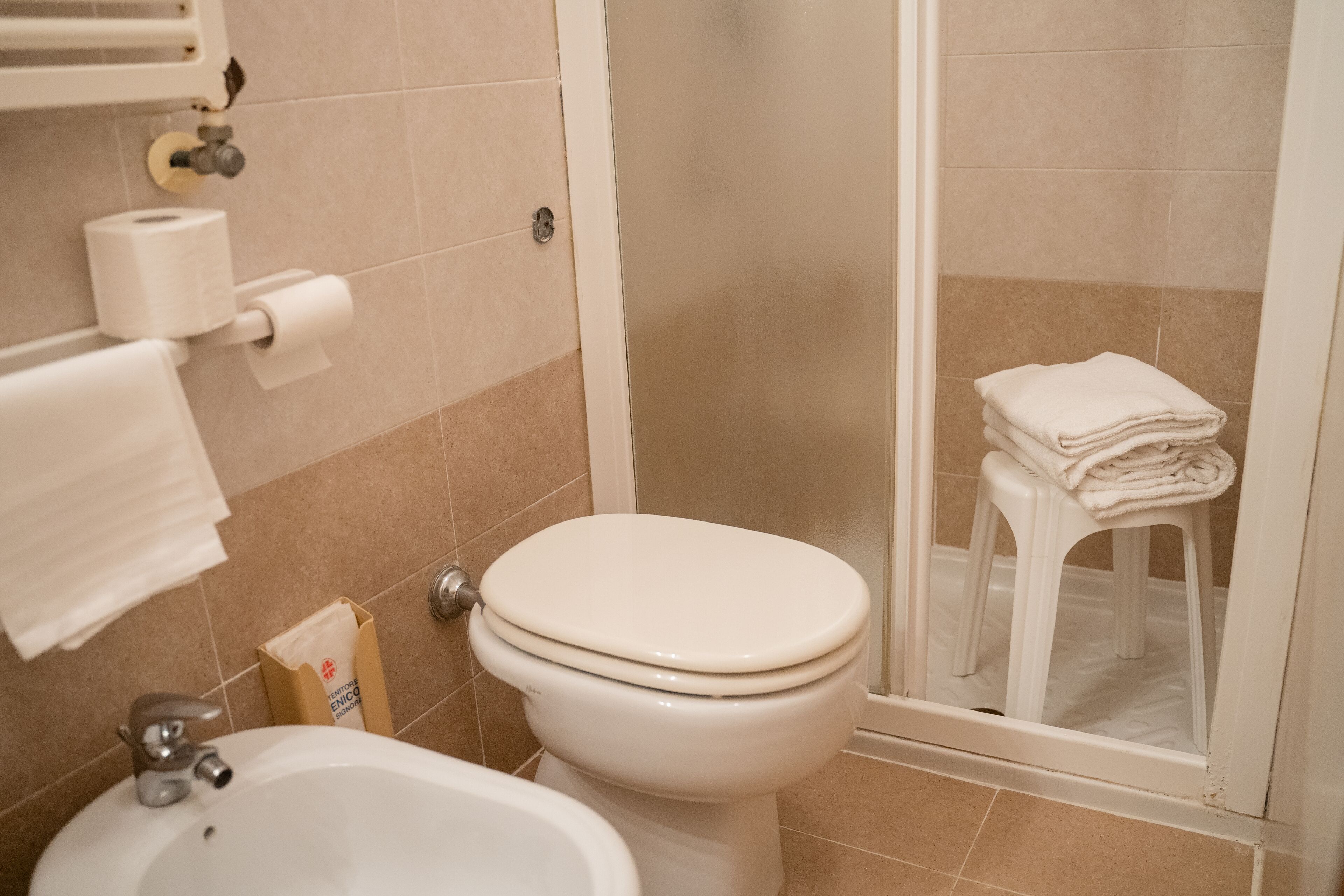 Un baño con inodoro, lavamanos y zona de ducha.