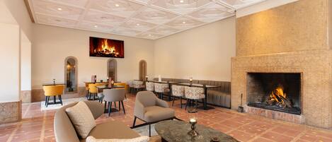 A spacious lobby with a fireplace, comfortable seating, and a dining area.