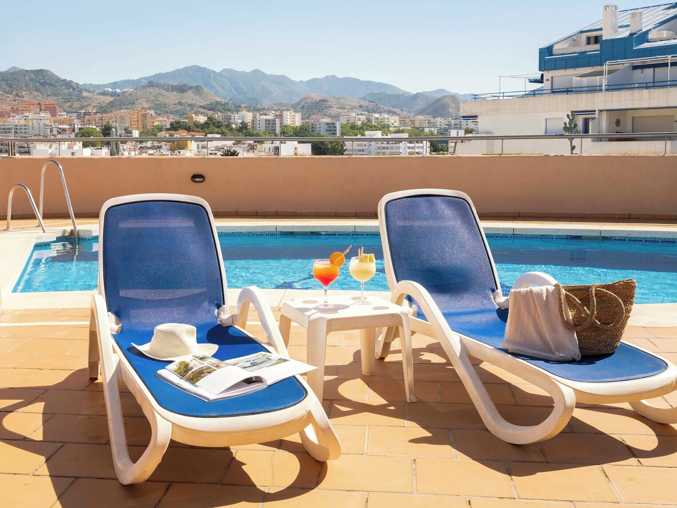 Una piscina al aire libre de temporada, sillones reclinables de piscina