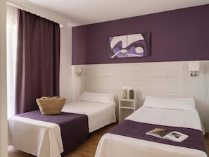 A hotel room with two beds, a nightstand, a wall-mounted painting, and a window with curtains. - Ona Princesa Playa (Marbella)