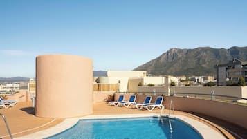 Una piscina al aire libre de temporada, tumbonas