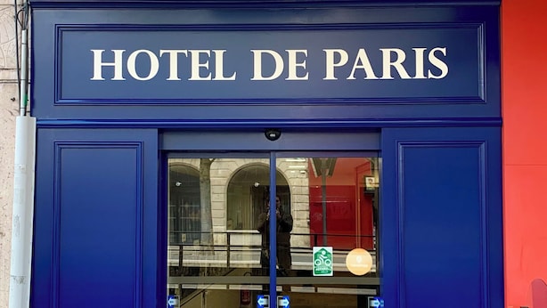 Una entrada azul con letrero 'HOTEL DE PARIS'.