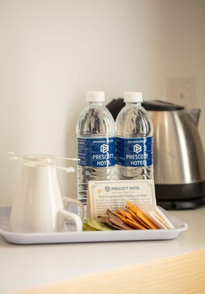 A tray with two bottles of drinking water, a pitcher, and a tray of snacks at a hotel. - Prescott Hotel KL Medan Tuanku (Kuala Lumpur)