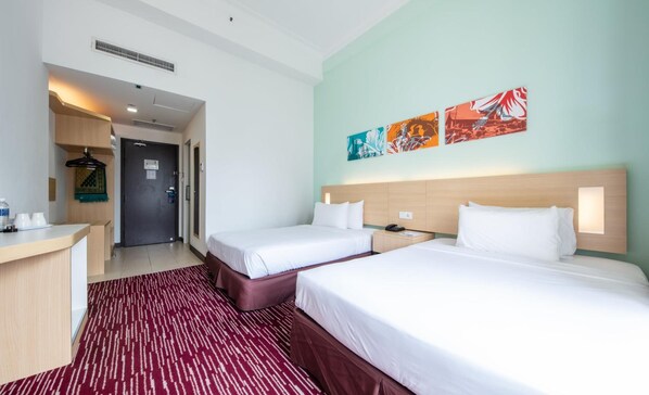 A hotel room with two beds, a desk, a chair, a red patterned rug, and artwork on the wall. - Prescott Hotel KL Medan Tuanku (Kuala Lumpur)
