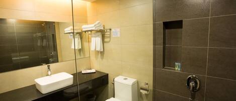 A modern bathroom with a black sink, white toilet, and a glass-enclosed shower area.