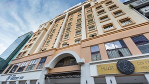 Um hotel com fachada moderna, vários andares e uma placa chamativa de cafeteria.