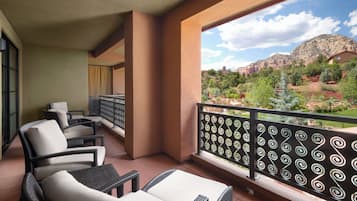 Un balcone con mobili in vimini e vista su un paesaggio montuoso.