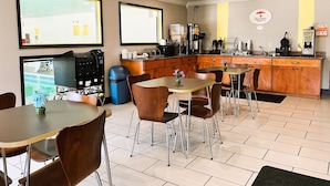 A modern hotel room with a kitchenette, dining area, and a large window. - Super 8 by Wyndham Vincennes (Vincennes)