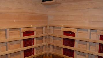 A corner of a wooden room with built-in red storage compartments and a digital control panel on the ceiling.
