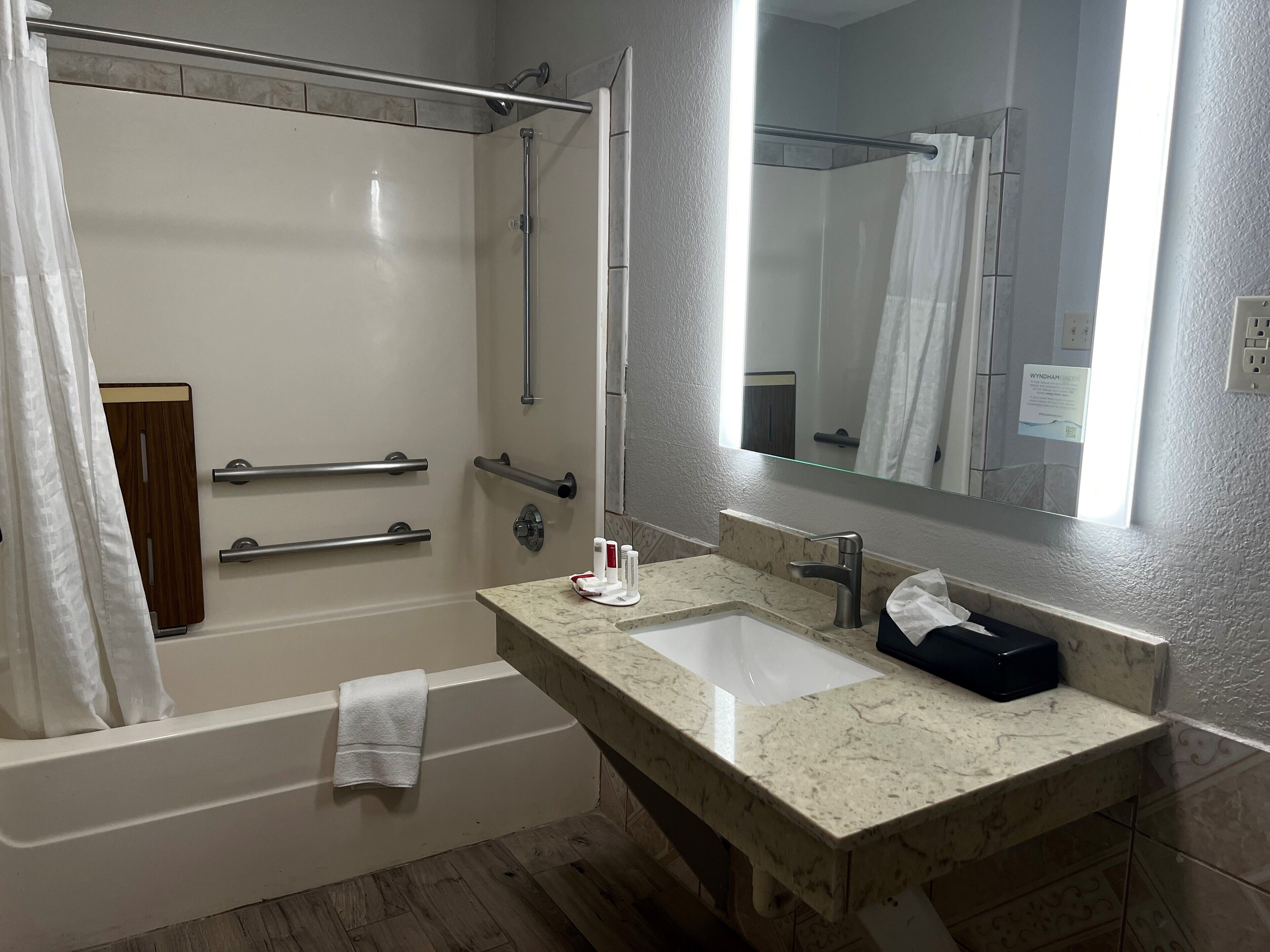 Un baño moderno con bañera, lavamanos y espejo.