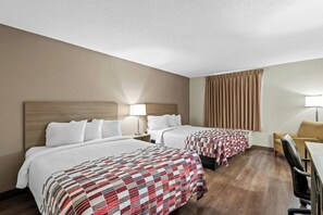 A hotel room with two beds, a desk, a chair, a lamp, and a window with curtains. - Red Roof Inn Etowah - Athens, TN (Etowah)