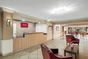 Een hotel lobby met een receptiebalie, een bordje voor gratis Wi-Fi en een zithoek.