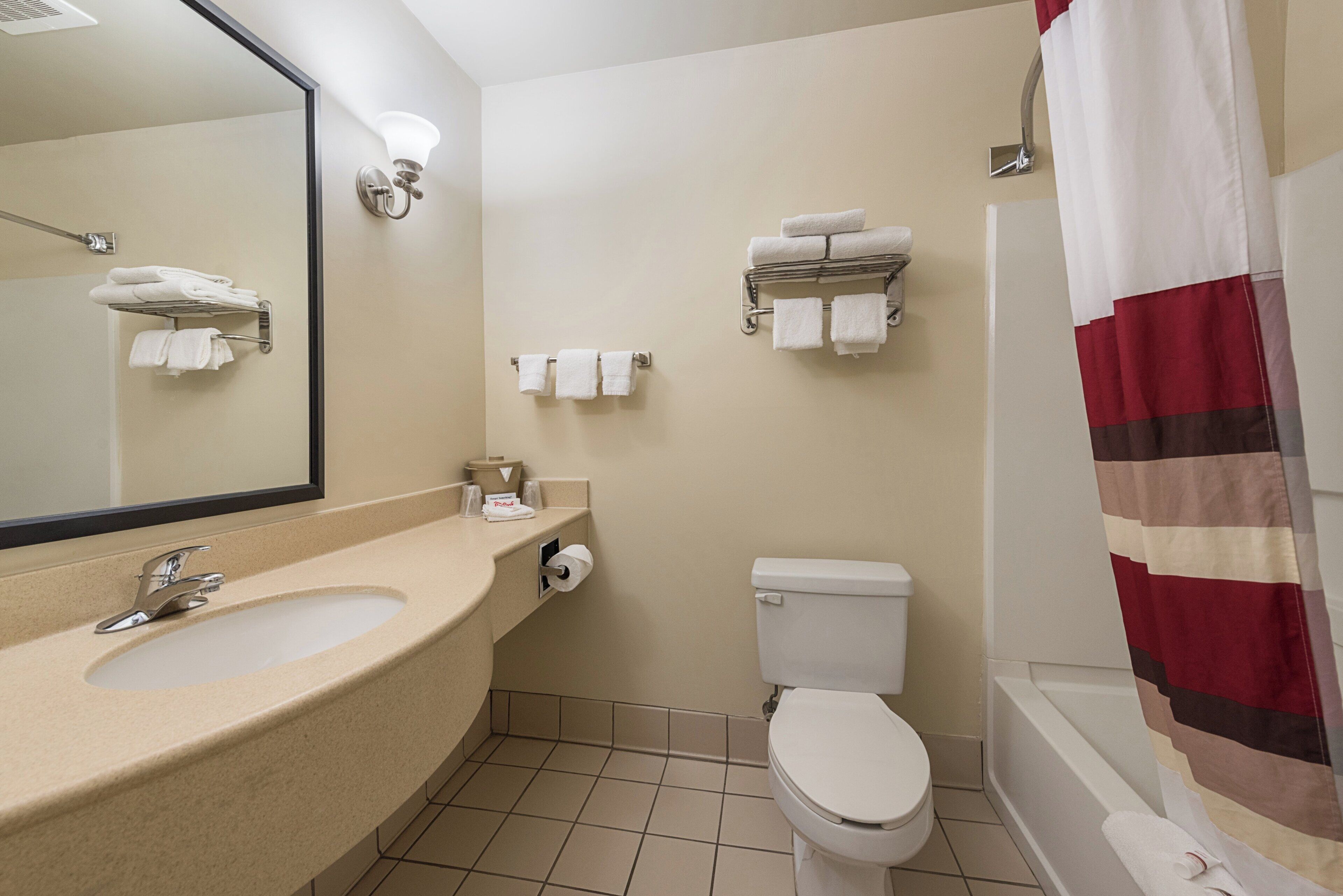 Baño con lavabo, inodoro y cortina de ducha.