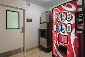 Een hotelkamer met een minibar, een koelkast en een drankdispenser van Coca-Cola.
