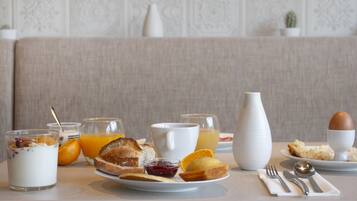 A breakfast setting with various food items and drinks on a table.