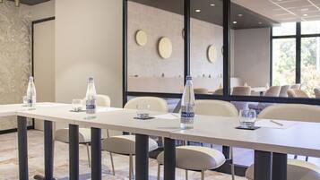A conference room with a long table, chairs, water bottles, and glasses.