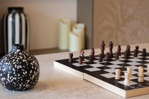 A chessboard with pieces, a vase, and candles. - Brit Hotel Nantes La Beaujoire Parc Expo (Nantes)