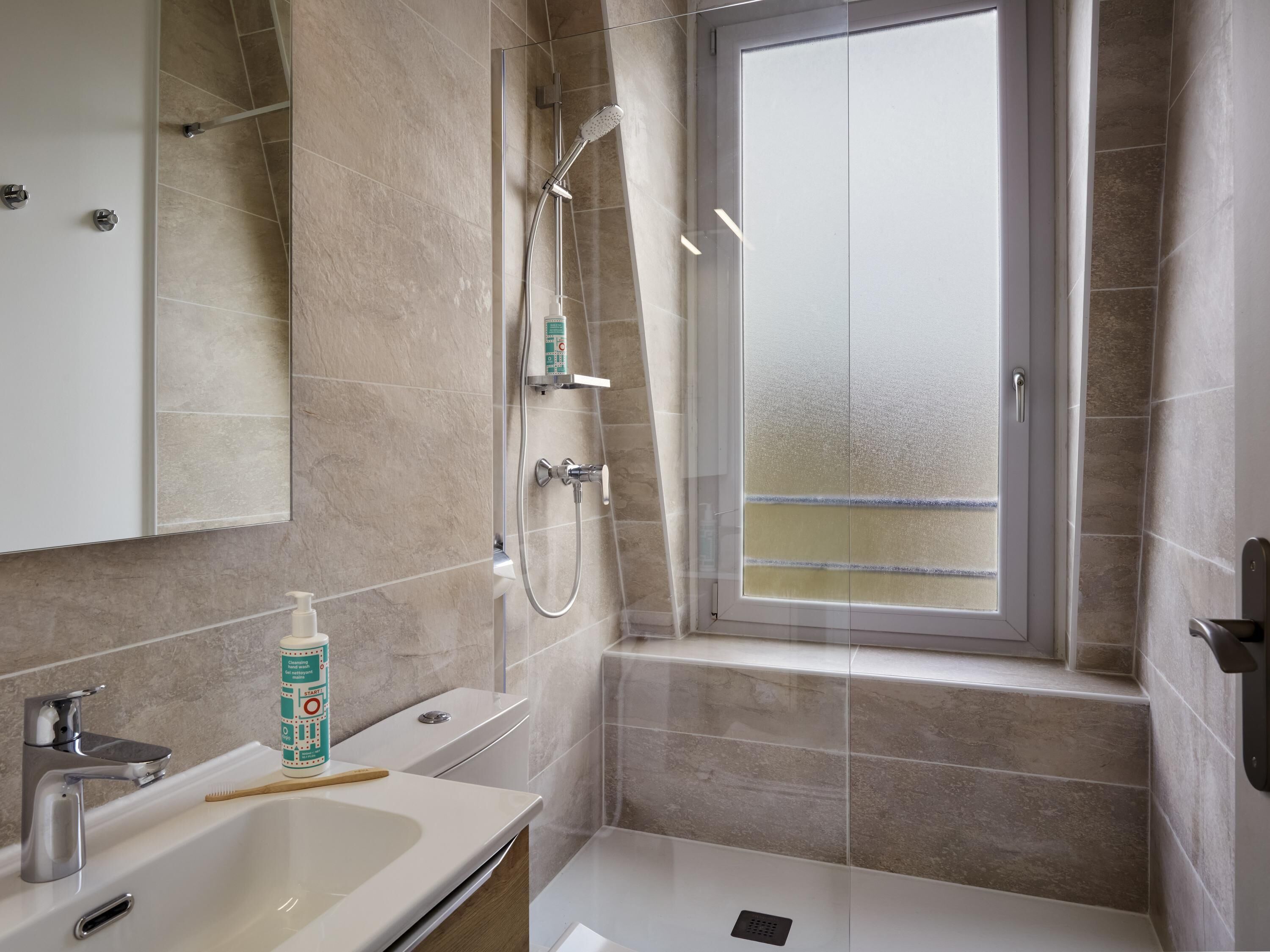 Ein modernes Badezimmer mit Dusche, Toilette und Waschbecken.