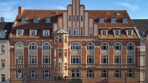 Un edificio histórico con fachada simétrica, múltiples ventanas y una torre central.