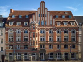 A historic building with a symmetrical facade, multiple windows, and a central tower.