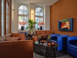 Ein stilvoller Lounge-Bereich mit Ledersofas, einem Kamin und großen Fenstern.