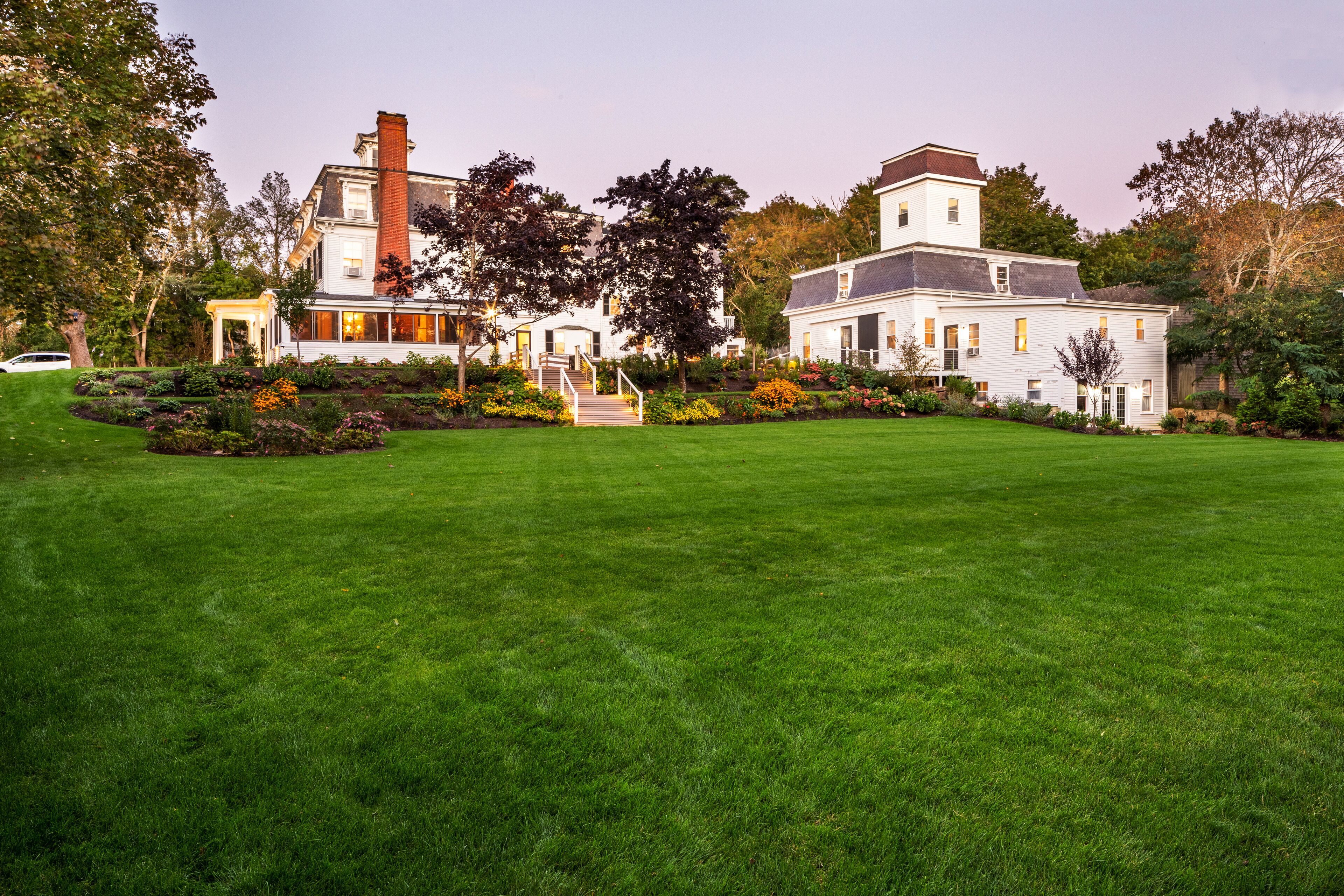 A large, two-story house with a well-maintained lawn and garden.